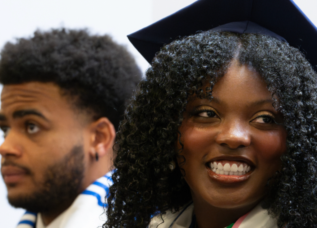 two smiling African American college students in cap and gown